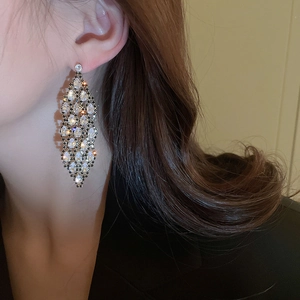 Macro shot of elegant leaf-shaped silver needle drop earrings with sparkling zircons