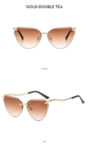 Detail of rimless cat-eye sunglasses with gradient brown lenses and gold snake-textured legs