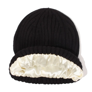 Détail du bonnet en maille noire avec doublure en satin crème pour protéger les cheveux