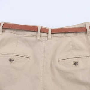Detail view of khaki casual shorts with brown belt and buttoned back pocket detail
