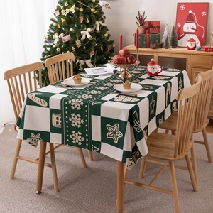 Waterproof polyester Christmas tablecloth featuring festive green prints on a wooden table