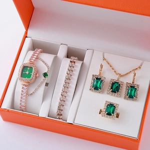 Luxury rose gold jewelry set with emerald green stones and diamond accents in gift box