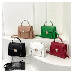 Detailed close-up of colorful women's flap bags with golden round locks on a tiered display