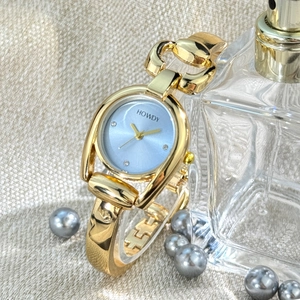Detail of golden horseshoe case watch with light blue dial and sparkling crystal markers