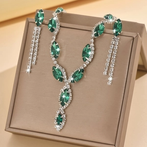 Detailed view of emerald-cut crystal necklace and tassel earrings on a jewelry box