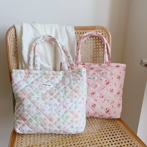 Close-up of quilted floral cotton tote bags with 'Simple Wish' label on a vintage chair