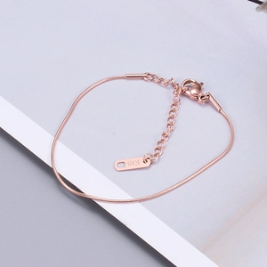 Macro view of rose gold snake chain with adjustable clasp and K18 engraved tag