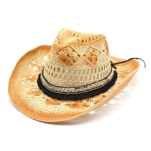 Women's hollow straw sun hat with bohemian fringe band and wide wavy brim for beach wear