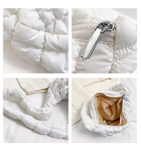 Detail view of white quilted puffer bag showing silver zipper and nylon texture