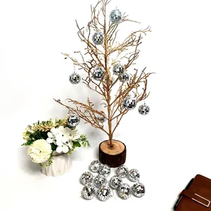Silver mirror disco balls hanging on golden branches for wedding and party decorations