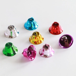Vue détaillée de huit petites cloches en métal brillant multicolores pour le bricolage