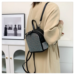 Close-up of black mini leather backpack with sparkling rhinestones worn on shoulder
