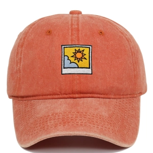 Detailed close-up of orange washed cotton baseball cap with sun and cloud embroidery