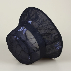 Détail d'un chapeau cloche en dentelle bleu marine avec broderie papillon et maille