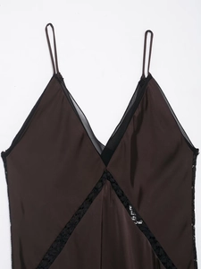 Dettaglio dell'abito midi in raso color cioccolato con pizzo nero sullo scollo a V profondo