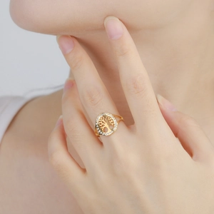 Close-up of 18K gold plated hollow tree ring with sparkling zircon stones on finger