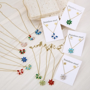 Close-up of gold stainless steel necklace and earring sets with colorful crystal petals