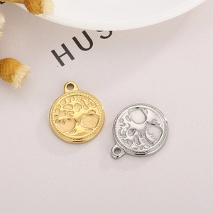 Detailed close-up of gold and silver Tree of Life pendants on a clean white plate