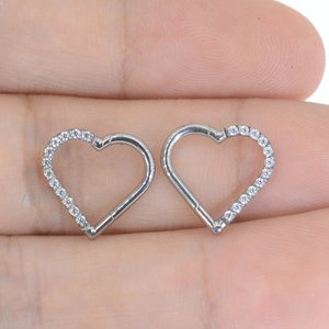 Macro view of a heart-shaped silver G23 titanium hoop ring with tiny inlaid diamonds