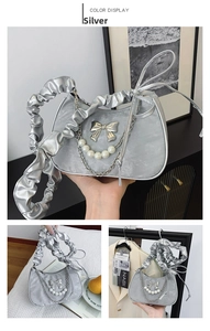 Detailed silver crescent shoulder bag with metallic bow and elegant pearl chain pendants