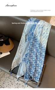 Detail of cotton linen scarf featuring blue feather prints and fringe tassels