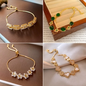 Detail of adjustable gold-plated bracelets featuring H-link, emerald, and floral charms