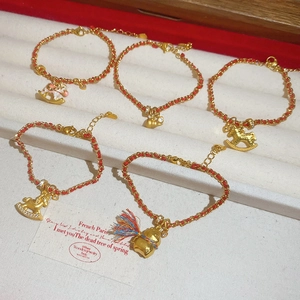Vue macro détaillée des breloques plaquées or 24K et de la collection de bracelets rouges