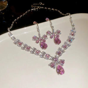 Detail of pink pear-cut zircon necklace and earrings set on white curved stand