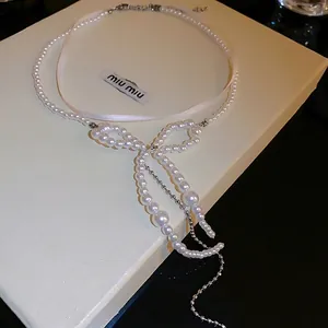 Elegant double-layered pearl necklace with bowknot pendant and metallic tassels