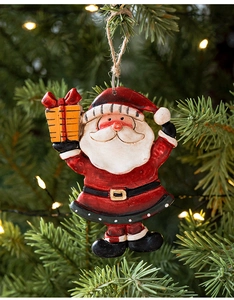Detailed view of resin Santa ornament hanging on a Christmas tree with warm lights