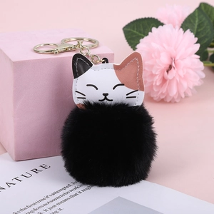 Detail of cute tricolor lucky cat keychain with large black faux rabbit fur pompom