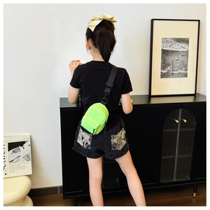 Detail of neon green nylon mini crossbody bag with adjustable strap worn by a model