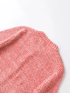 Detailed view of the red and white melange knit texture and ribbed crew neckline