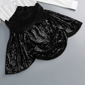 Détail d'une chemise blanche boutonnée et d'une mini-jupe à paillettes noires texturées