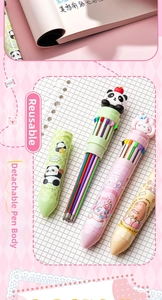 Close-up of 10-color cartoon ballpoint pens with silicone toppers on a pink notebook