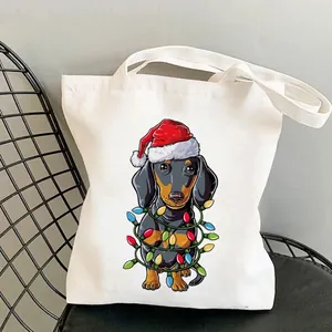 Close-up of a white canvas tote bag featuring a festive Christmas dachshund print