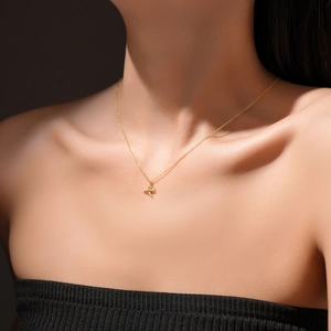 Close-up of minimalist S925 sterling silver airplane pendant on a dainty gold neck chain