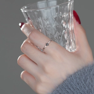 Elegant S925 sterling silver ring with black clover charm worn by a female model