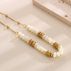 Detail of beaded necklace with gold plated chain and elegant white round pearls