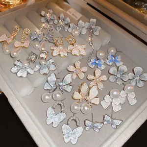 Floral crystal pearl earrings set featuring butterfly and flower designs in gold finish