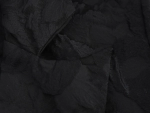 Close-up of black jacquard fabric showing intricate floral texture and premium weaving