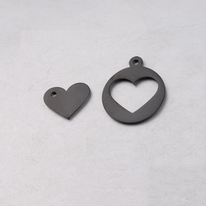 Detailed view of large hollow heart pendant and small solid heart charm in dark metal