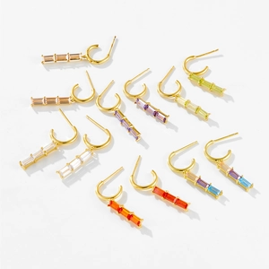 Macro shot of 925 silver gold-plated earrings with rectangular colorful zircon stones