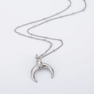 Polished titanium steel crescent moon necklace with thin bead chain on white background