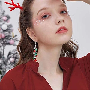 Detailed view of long tassel Christmas earrings with red and green bells on a model