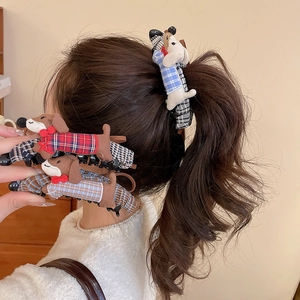 Close-up of adorable dachshund fabric hair clips featuring plaid patterns and red bows