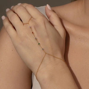 Detail of a gold-plated finger bracelet featuring five vibrant multicolored zircons