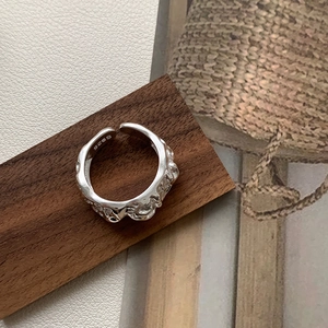 Macro shot of S925 sterling silver ring with irregular lava texture on wooden block