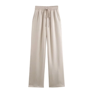 Détail du pantalon plissé abricot avec taille élastique à cordon et texture riche