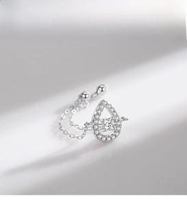 Macro detail of S925 silver teardrop ring with pavé diamonds and a dangling center stone
